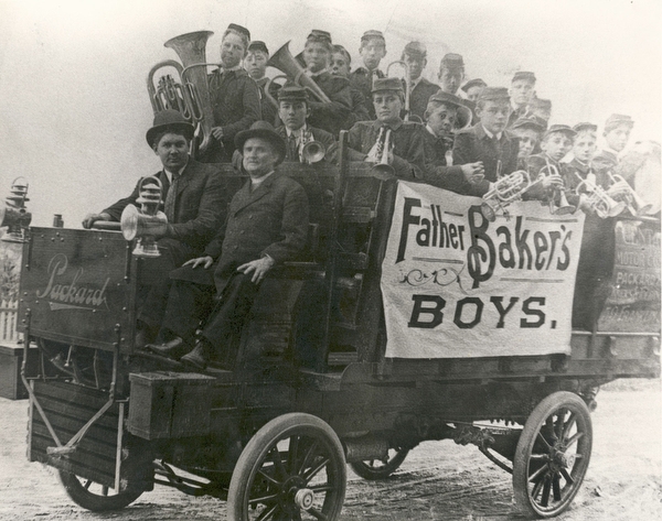 Father Baker and his boys take a ride in an old Packard truck